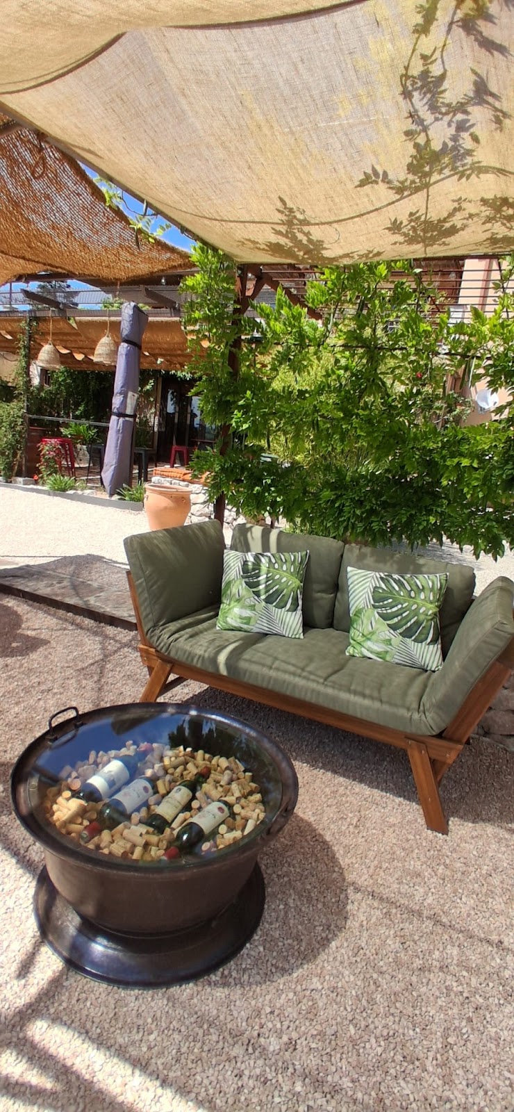 Terrasse extérieure ensoleillée avec foyer et mobilier de détente
